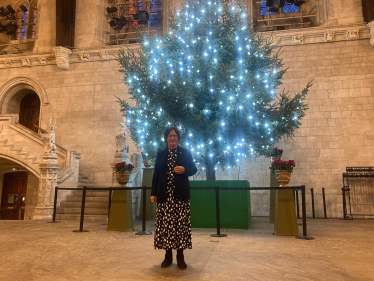 Pauline Latham OBE MP stands in front of a Christmas Tree